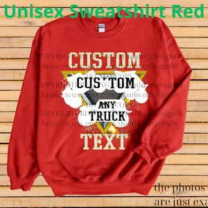 Może przedstawiać: Czerwona bluza unisex z napisem "CUSTOM ANY TRUCK TEXT" w kolorze białym i czarnym, na ż&oacute;łtym tr&oacute;jkącie i białych kształtach przypominających chmury. U g&oacute;ry napis "Unisex Sweatshirt Red".