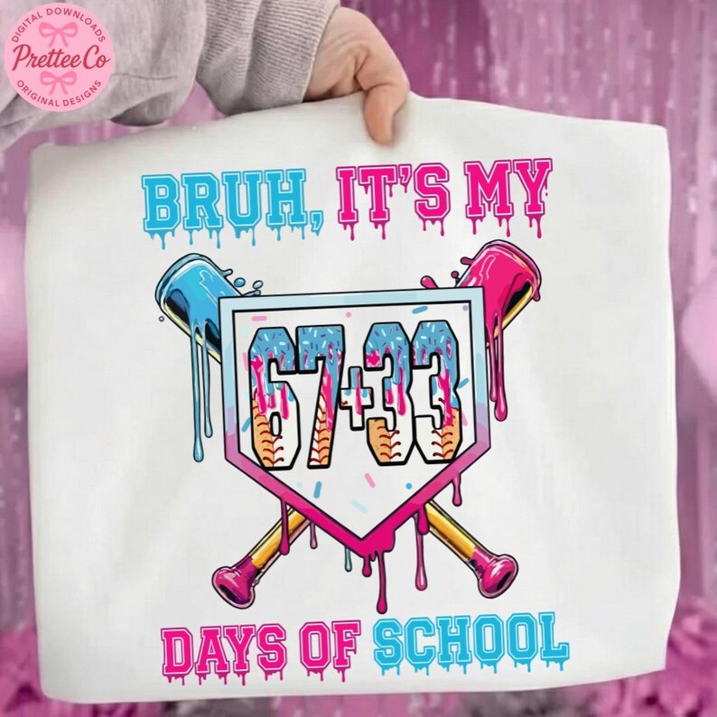 Pode incluir: Camiseta branca com o texto "BRUH, IT'S MY DAYS OF SCHOOL" em azul e rosa. O design inclui um gr&aacute;fico tem&aacute;tico de beisebol com os n&uacute;meros "67+33" dentro de uma forma de placa de base rosa e branca, e bast&otilde;es de beisebol cruzados.