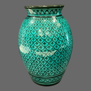 May include: A turquoise ceramic vase featuring a repeating black scale pattern across its rounded body. The neck and base are accented with horizontal black line detailing, creating a consistent geometric design throughout the entire vessel.