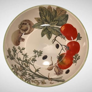 May include: A round ceramic serving bowl with a cream-colored interior and a green rim. The bowl features a botanical design of tomatoes, mushrooms, garlic, basil, and parsley. The design is in shades of red, green, brown, and black.