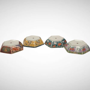 May include: Four hexagonal ceramic bowls with white interiors and flat bases. Each bowl features a distinct exterior pattern: one with red and orange floral motifs, one with yellow floral designs, one with green and orange, and one with purple floral art.