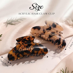 May include: Two acrylic hair claw clips with a tortoiseshell pattern. One clip is labeled "Emily", the other "Amelia". The clips measure 9cm long, 4.5cm wide, and 1.8cm high.