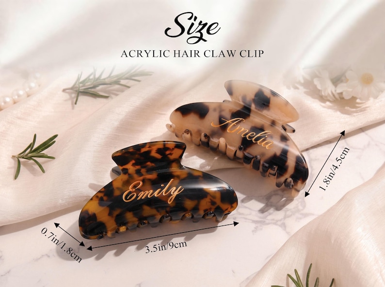 May include: Two acrylic hair claw clips with a tortoiseshell pattern. One clip is labeled "Emily", the other "Amelia". The clips measure 9cm long, 4.5cm wide, and 1.8cm high.