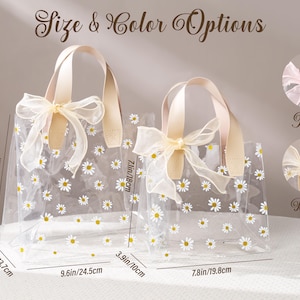 May include: Two clear tote bags with daisy patterns and beige handles. The larger bag is 9.6 inches wide and 8.7 inches tall, while the smaller one is 7.8 inches wide and 7.1 inches tall. The text "Size & Color Options" is at the top.
