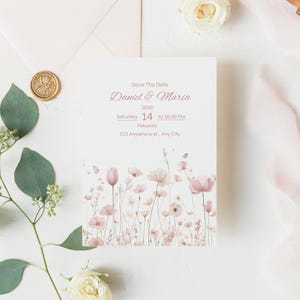 K&ouml;nnte beinhalten: Eine wei&szlig;e Save The Date Karte mit rosa Blumenillustrationen am unteren Rand. Der Text lautet: Save The Date, Daniel & Maria, 2030, Saturday 14 at 10:00 Pm, Feburary, 123 Anywhere st., Any City. Die Karte ist mit gr&uuml;nen Eukalyptusbl&auml;ttern verziert.