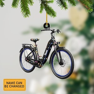 May include: Black bicycle ornament with blue accents and colorful lights. The word "Name" is printed on the side. The ornament is hanging from a gold string. The text "NAME CAN BE CHANGED" is on a yellow rectangle.
