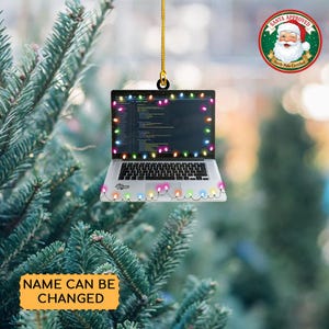 May include: A laptop-shaped Christmas ornament with a string of colorful lights around the screen and base. The screen displays code, and the ornament has a gold string for hanging. The text "Name Can Be Changed" is on a yellow banner.