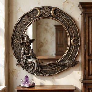 May include: A circular bronze-toned wall mirror featuring an ornate frame decorated with celestial symbols, runes, and a pentagram. A sculpted figure wearing a pointed hat and robes sits on a broomstick, holding a small cat, integrated into the frame.
