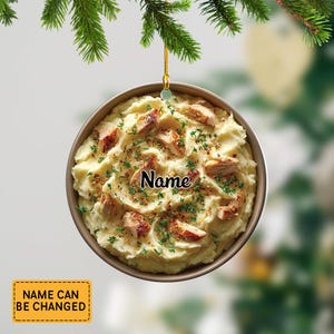 May include: A round Christmas ornament featuring a mashed potato and chicken dish. The ornament has a gold rim and is topped with pieces of chicken and herbs. The word "Name" is written on the ornament. A yellow tag reads "NAME CAN BE CHANGED".