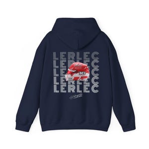 Może przedstawiać: Męska bluza z kapturem w kolorze granatowym z białym nadrukiem wyścigowego kasku i powtarzającym się tekstem "LERCLEC".