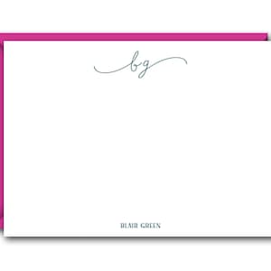 May include: White stationery card with a pink border. The card has a cursive monogram "bg" in dark blue ink and the text "BLAIR GREEN" in dark blue ink at the bottom.