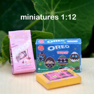 May include: Three miniature boxes of Easter treats. A pink box with the word "Lindor" on it, a blue box with the word "Oreo" and the text "Easter Fun Cookie Kit", and a yellow box with pink and white candy.