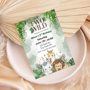 May include: A birthday invitation with the text "He is TWO WILD" and "Oliver's 2nd Birthday". The invitation features illustrations of a giraffe, lion, and elephant, with a green and white watercolor background.