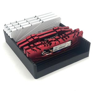 May include: A black tray contains computer RAM sticks. There are silver and red RAM sticks. The red RAM sticks have the text "Ripjaws V" and "G.Skill" printed on them. The silver RAM sticks are stacked in a row.