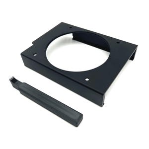 Puede incluir: Soporte met&aacute;lico negro con una gran abertura circular y varios agujeros peque&ntilde;os. Un peque&ntilde;o cepillo rectangular negro con cerdas se coloca junto al soporte. Los art&iacute;culos est&aacute;n sobre un fondo blanco.