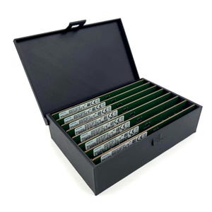 Könnte beinhalten: Eine schwarze rechteckige Box mit einem Klappdeckel, die geöffnet ist, um mehrere grüne Leiterplatten freizulegen. Die Platinen sind mit Text beschriftet und ordentlich in der Box angeordnet. Die Box steht auf einer weißen Oberfläche.