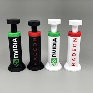May include: Four adjustable GPU support brackets standing upright. Two are black with green or red accents, and two are white with green or red accents. The brackets feature the text NVIDIA or RADEON printed vertically on the front side.