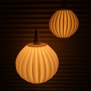 May include: Two pendant lights with a ribbed, spherical design. The lampshades are a warm, off-white color, and the light they emit is soft and inviting. The background is a dark brown with horizontal lines.