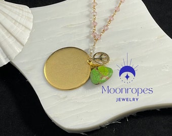 30” Rose quartz gold-filled necklace with Green Copper Turquoise Pendant and Gold Peace Sign resting upon a large gold disc.