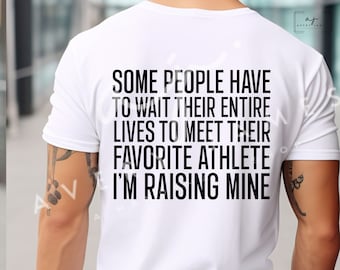 May include: White t-shirt with black text that reads "Some people have to wait their entire lives to meet their favorite athlete. I'm raising mine."