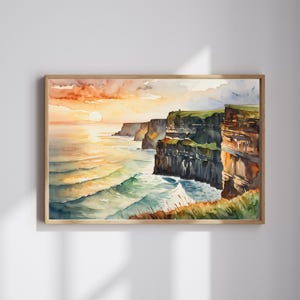 May include: Watercolor painting of the Cliffs of Moher at sunset. The artwork depicts the rugged cliffs meeting the ocean, with the sun setting over the water. The sky is a blend of orange, yellow, and pink hues, and the waves are a mix of blue and green.