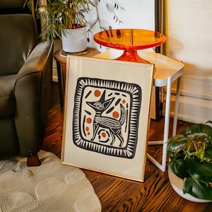 May include: A framed print of a stylized black and white illustration of a dog with orange accents. The dog is surrounded by a geometric pattern.