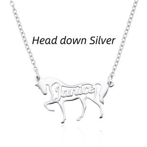 May include: A silver-toned necklace featuring a pendant shaped like a horse with its head down. The name Janice is cut out from the center of the horse's body. The text Head down Silver is printed above the pendant, which hangs from a thin chain.