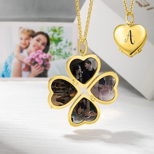 Puede incluir: Collar con colgante en forma de corazón dorado, con un diseño de trébol de cuatro hojas que contiene cuatro fotos pequeñas. También se muestra un colgante en forma de corazón separado con la letra "A". El collar cuelga de una cadena dorada.