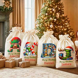 Peut inclure: Quatre sacs cadeaux de Noël crème avec fermetures à cordon. Chaque sac présente un design de vacances unique : un elfe, un bonhomme de neige avec un sucre d'orge, une lettre "D" remplie de maisons et un sapin de Noël. Les noms sont imprimés en dessous.