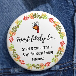 May include: A white round button with a cartoon turkey illustration and the text "Most likely to... Start Drama Then Say 'I'm Just being Honest'". The button is surrounded by a wreath of fall leaves.