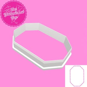 Peut inclure: Emporte-pièce en plastique blanc en forme d'octogone. L'emporte-pièce est présenté sur un fond rose. L'emporte-pièce est conçu pour découper une forme octogonale.