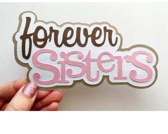 May include: Brown and pink paper cut-out sign that says "forever sisters".
