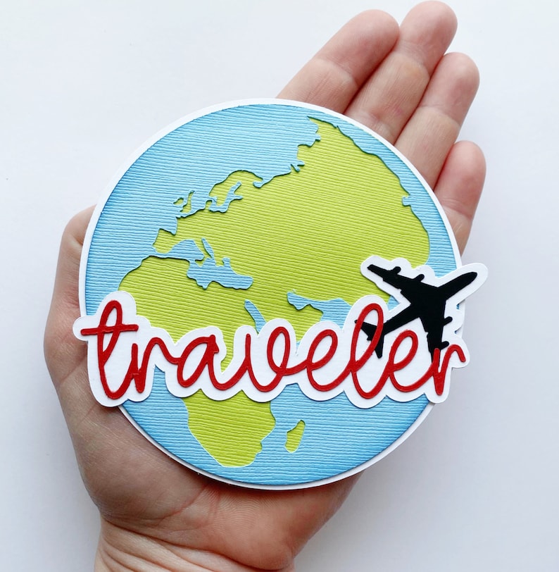 May include: A blue and green paper craft of the world with a red and white paper craft word "traveler" and a black paper craft airplane.