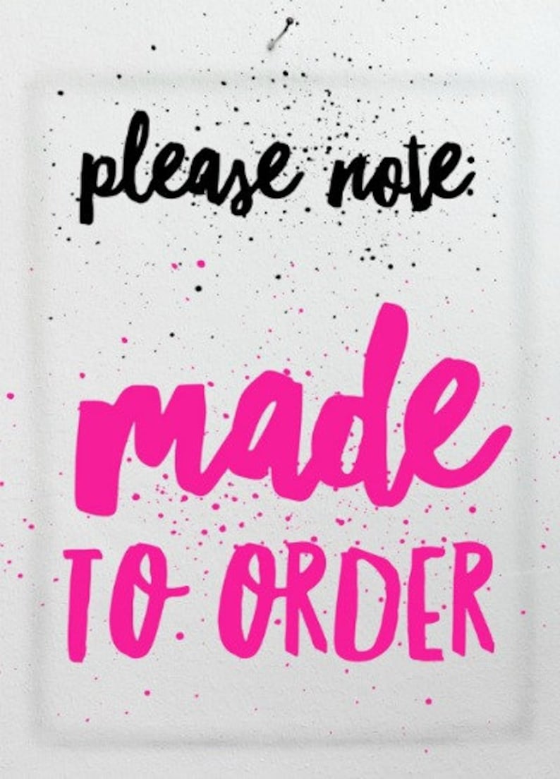Puede incluir: Un letrero rectangular blanco con texto negro que dice please note: y texto rosa brillante que dice made TO ORDER. El fondo est&aacute; decorado con un patr&oacute;n disperso de peque&ntilde;as salpicaduras de pintura negra y rosa en la superficie.