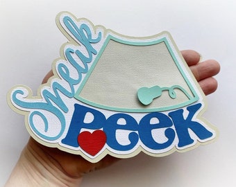 May include: A light blue and white card with the text "Sneak Peek" in blue and white lettering. A small red heart is next to the word "Peek". The card features a light blue outline of an ultrasound image with a light blue transducer.