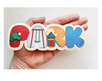 May include: A colorful paper craft spelling out the word "PARK" with images of a tree, swing set, and a small house with a slide.