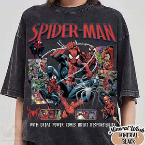 K&ouml;nnte beinhalten: Schwarzes T-Shirt im Mineral-Wash-Stil mit Spider-Man-Illustrationen und dem Text "SPIDER-MAN" in Rot und Blau. Der Text "WITH GREAT POWER COMES GREAT RESPONSIBILITY" ist ebenfalls enthalten.