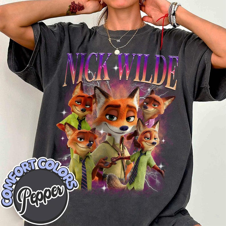 Puede incluir: Camiseta gris oscuro con un dise&ntilde;o de Nick Wilde de Zootopia. El dise&ntilde;o incluye m&uacute;ltiples im&aacute;genes del personaje zorro, el nombre "NICK WILDE" en una fuente degradada y el logotipo "Comfort Colors Pepper".