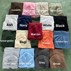 May include: A collection of folded hoodies in various colors, including chocolate, light pink, sand, and milita green. Other colors are ash, navy, white, black, forest green, begi, marron, orange, carolina blue, sport grey, light blue, grey, and brow.