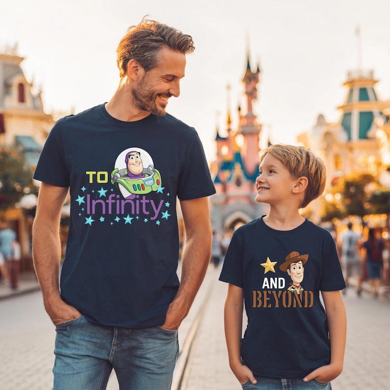 May include: Two navy blue t-shirts with cartoon graphics. One features Buzz Lightyear in a spaceship with the text "To Infinity". The other has Woody with the text "And Beyond". Both shirts have star accents.