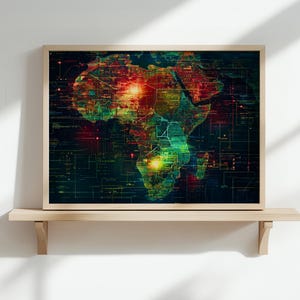 May include: A framed print of a map of Africa with a digital overlay. The map is in shades of green, red, and yellow, with a dark blue background. The print is hanging on a light wood shelf against a white wall.