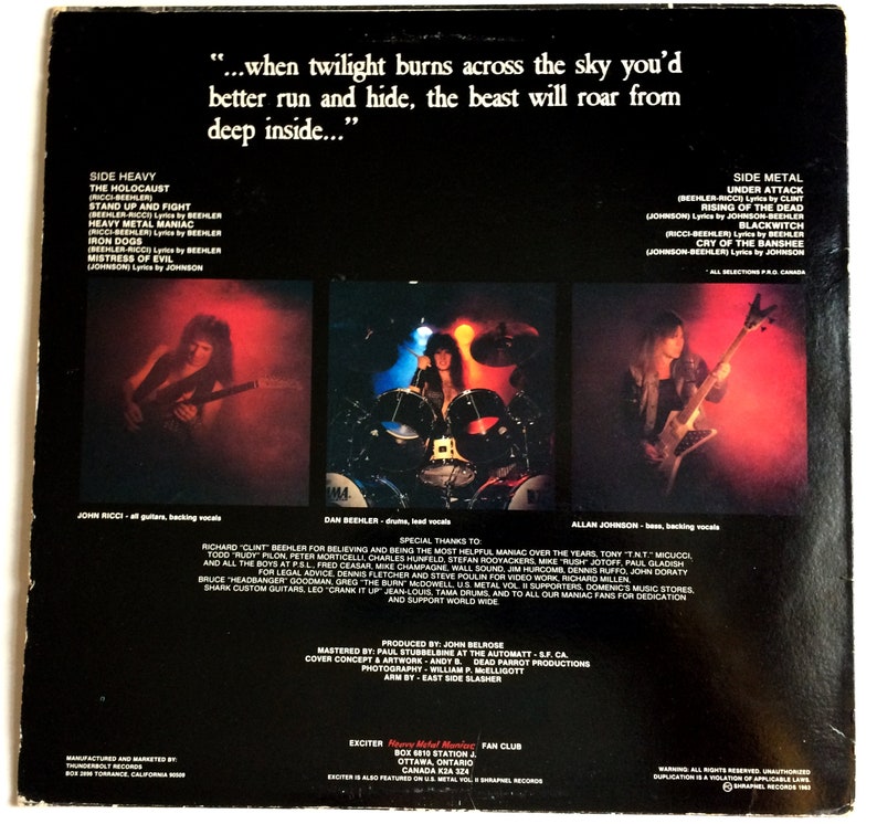 May include: Back cover of a vinyl record by the heavy metal band Exciter. The album cover features a black and white photo of the band members. The album title is "Heavy Metal Maniac" and the album's release date is 1983. The album's tracklist is listed on the back cover. The album's credits are also listed on the back cover.
