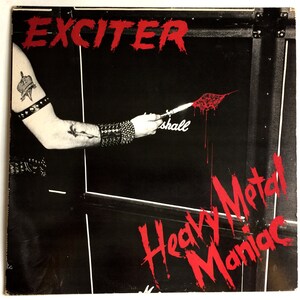 May include: A black and white album cover with the band name "Exciter" in red letters at the top. A person's arm is holding a knife and dripping red paint on the cover. The words "Heavy Metal Maniac" are written in red letters on the bottom of the cover.