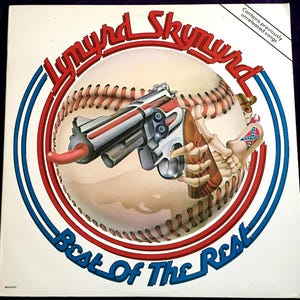 May include: A square vinyl record cover featuring a baseball graphic with a revolver held by a skeletal hand. The text reads Lynyrd Skynyrd, Best Of The Rest, and Contains previously unreleased songs. The design includes red and blue circular borders.