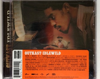 May include: A CD case with a red and orange background. The front of the case features a photo of a man with a black and white background. The text "Outkast - Idlewild" is printed in white on a red and orange background. The back of the case lists the songs on the album.