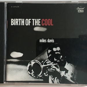 May include: A black and white photo of Miles Davis playing a trumpet. The album cover is for the album "Birth of the Cool" and features the Capitol Jazz logo.