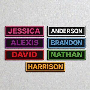 May include: A collection of rectangular name tags, each displaying a name in a bold, coloured font. Names include Jessica, Alexis, David, Anderson, Brandon, Nathan, and Harrison. Each name is on a black background with a coloured border.