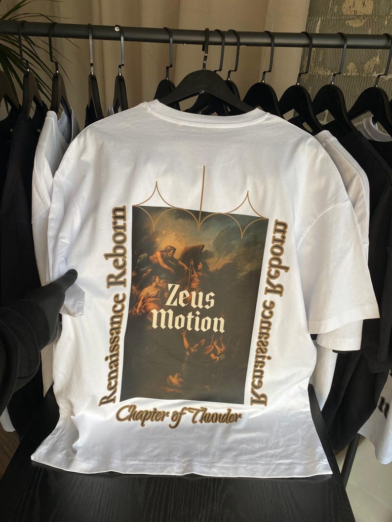May include: White t-shirt with a large graphic on the back featuring a classical painting with the text "Zeus Motion" and "Renaissance Reborn". The shirt also has the text "Chapter of Thunder".