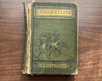 May include: An antique book with a green cover featuring the name "LONGFELLOW" in gold lettering. The cover also displays an illustration of white flowers and the word "ILLUSTRATED". The book's spine shows signs of wear.