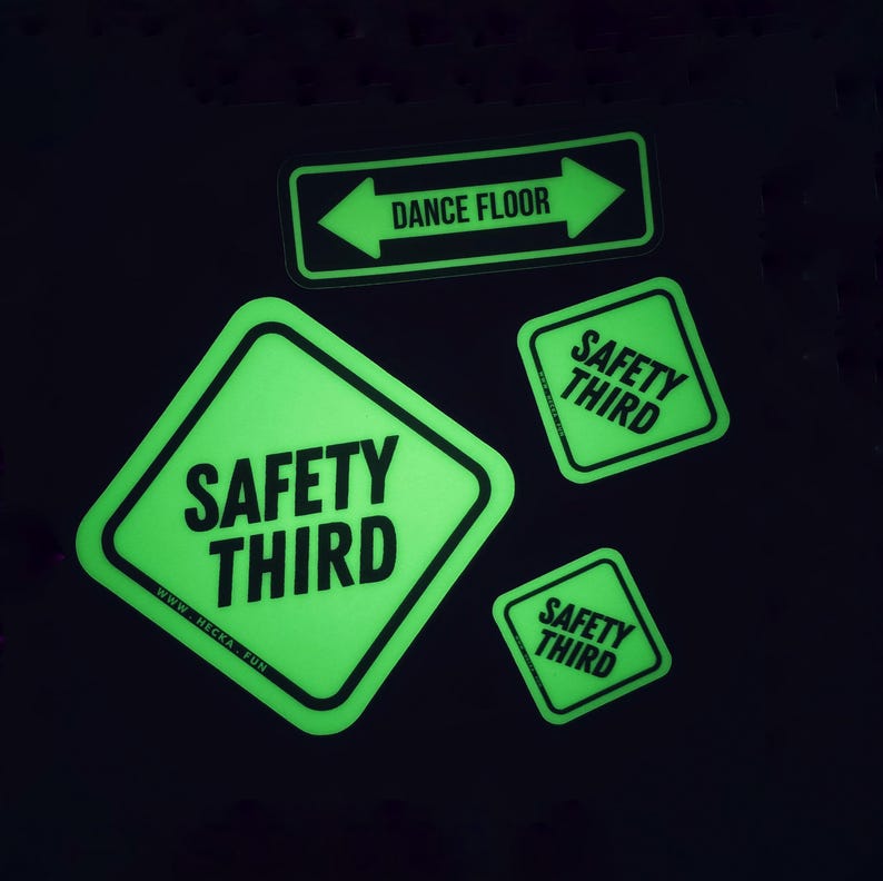 May include: Four neon green stickers with black text on a black background. The stickers include the phrases "DANCE FLOOR" with arrows, and "SAFETY THIRD". One sticker has the website address "WWW.HECKA.FUN".